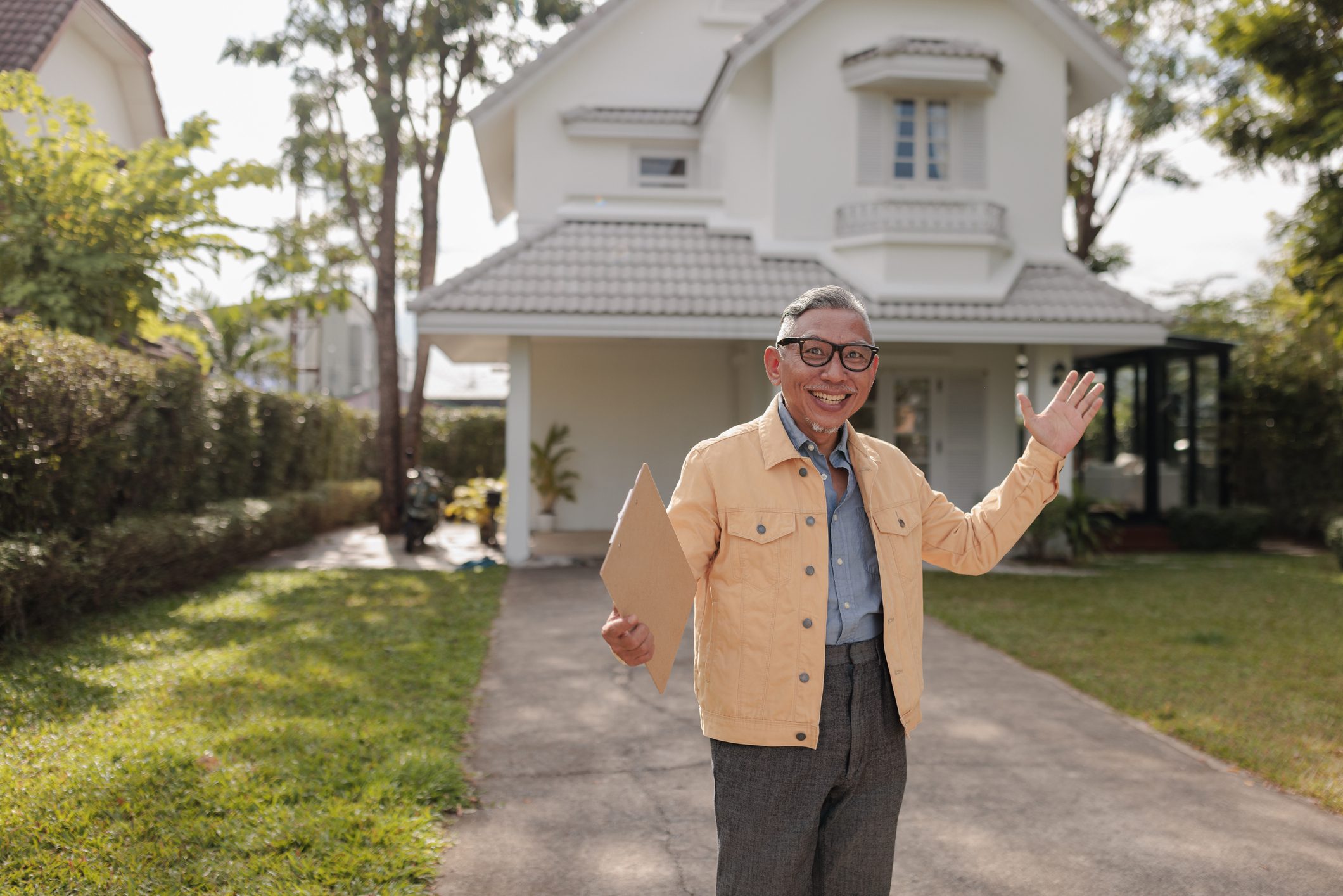 Happy homeowner with document outdoors