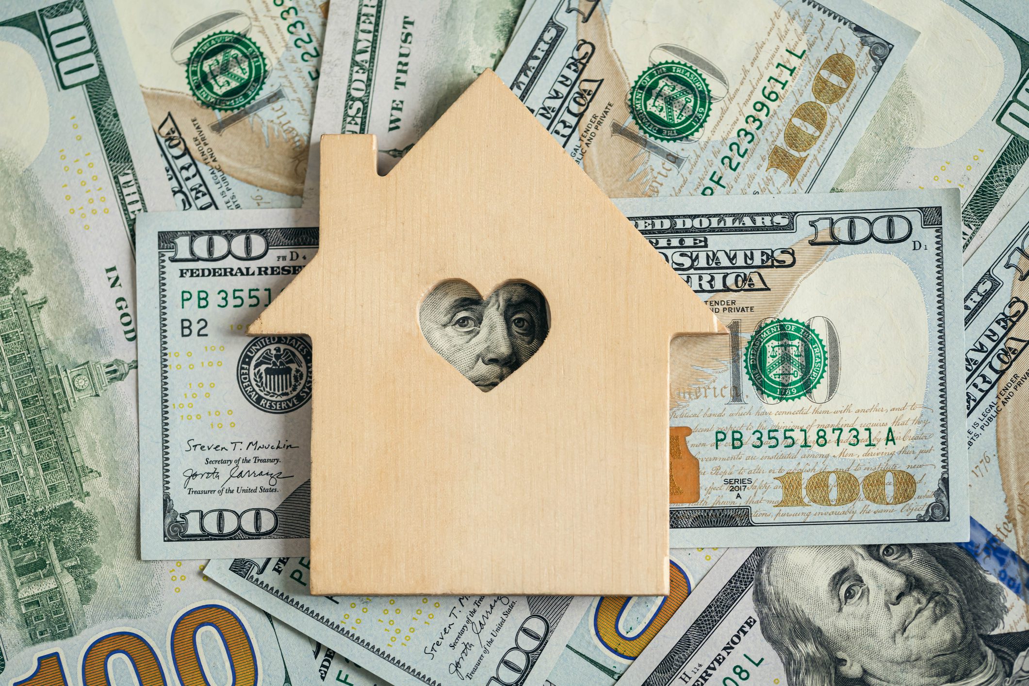 Wooden house on dollar bills